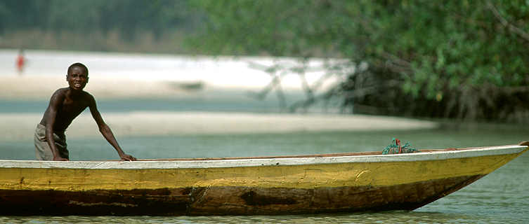 Boy fishing on canoe, Sierra Leone